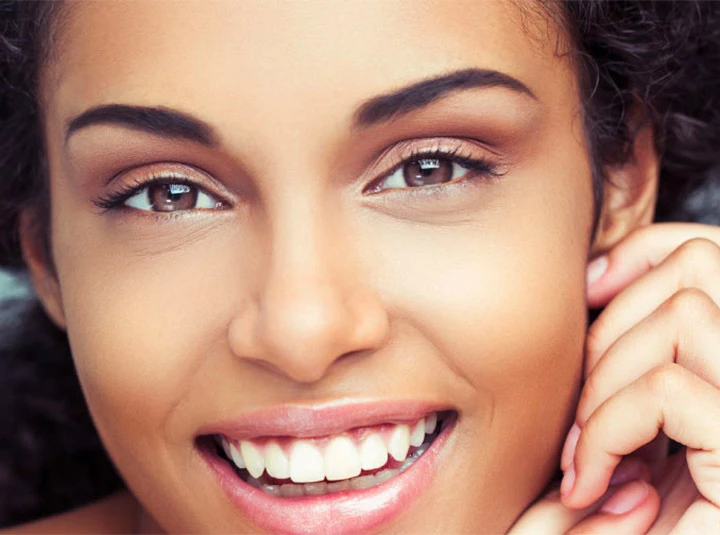 A smiling brunette woman talking on the phone